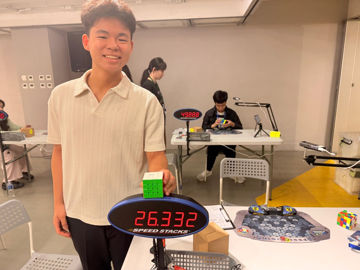 Jeco 手持 4×4 扭計骰，旁邊嘅比賽計時器顯示 26.332 秒